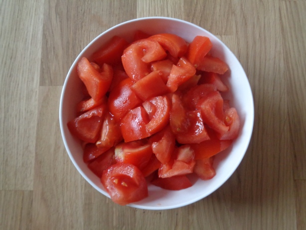 Die Tomaten in Stücke schneiden