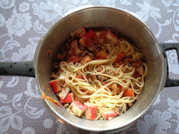 Wasser von Spaghetti abschütten und mit den Meerfrüchten vermengen