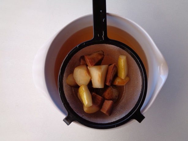 Die Birnenstücke mit einem Sieb herausfiltern