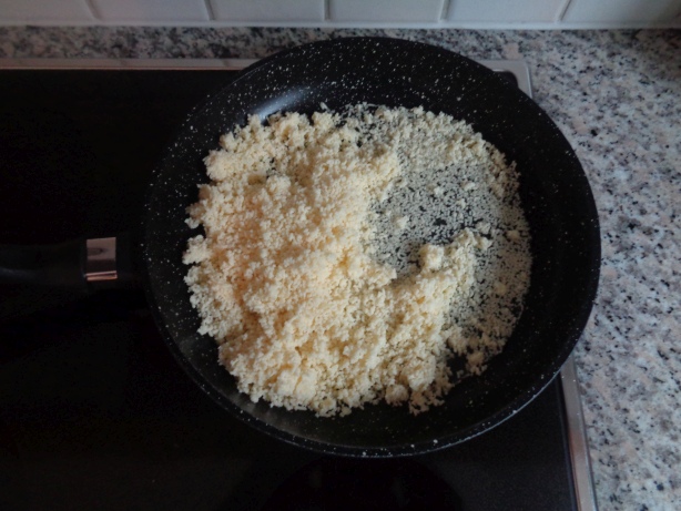 Reibkäse und Weisswein in eine Bratpfanne geben und erhitzen