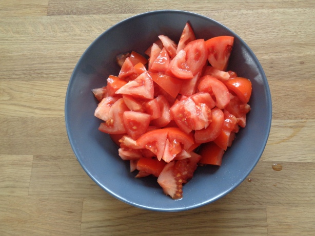 Die Tomaten in Stücke schneiden