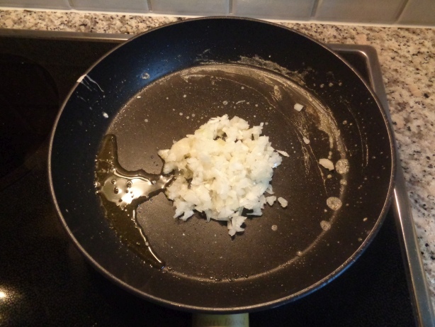 Die Zwiebel schälen, hacken, in eine Bratpfanne geben und andünsten