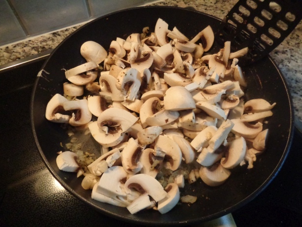 Die Champignons und einen gehäuften Esslöffel Kräuter dazu geben