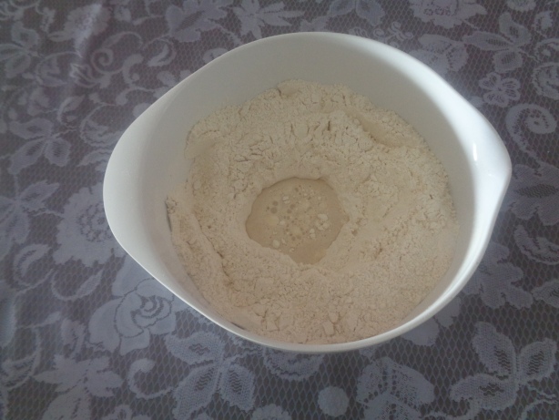 Hefe und Wasser zum Mehl geben