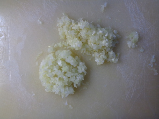 Den Knoblauch und die Zwiebeln häuten und klein hacken