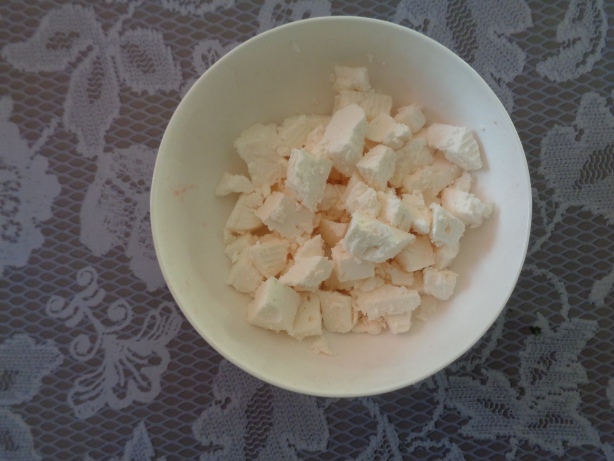 Den Käse in kleine Stücke schneiden