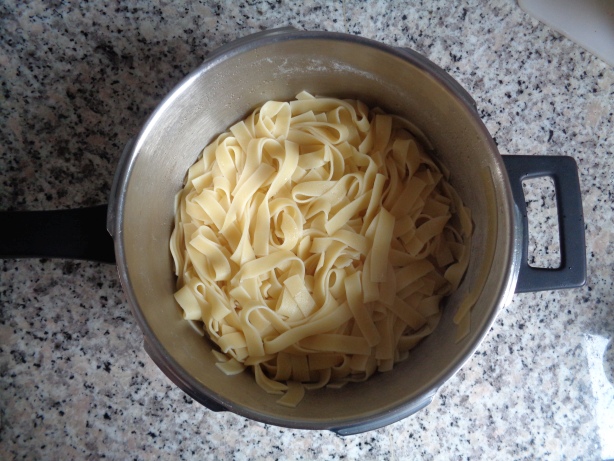 Das Wasser von den Nudeln abtropfen