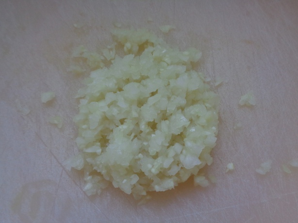 Knoblauch und Zwiebel rüsten und fein hacken