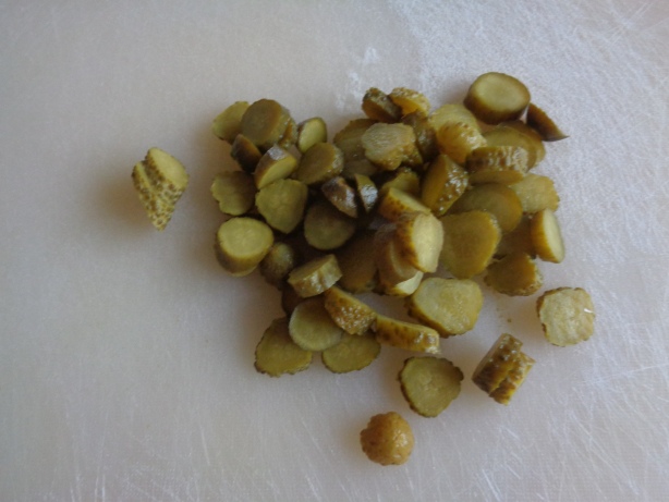 Ein paar Gewürzgurken in Scheiben schneiden und beigeben