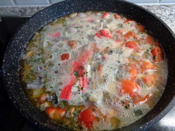 Die Meerfrüchte beigeben kurz weiterbraten und mit Wein ablöschen