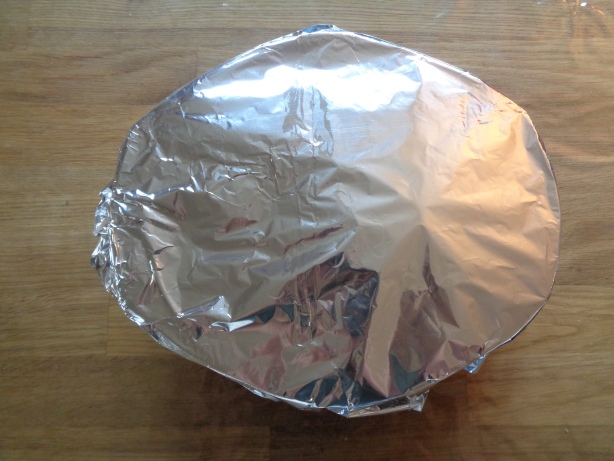 Die Backform mit Aluminiumfolie decken